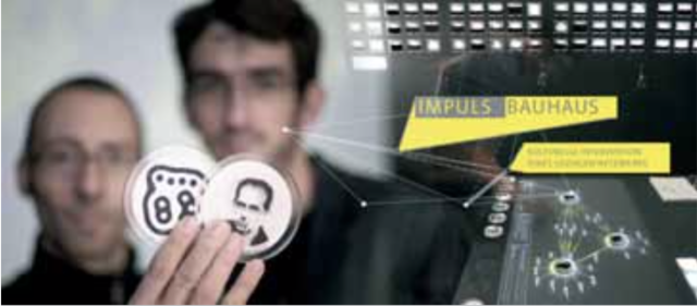 Die Projektautoren Jens Weber und Andreas Wolter mit zwei Personensteinen des interaktiven Tisches, daneben das ImpulsBauhaus-Logo